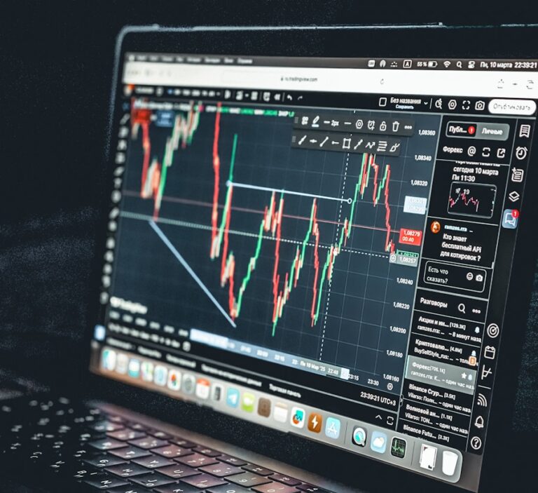Laptop displays a stock market trading chart.
